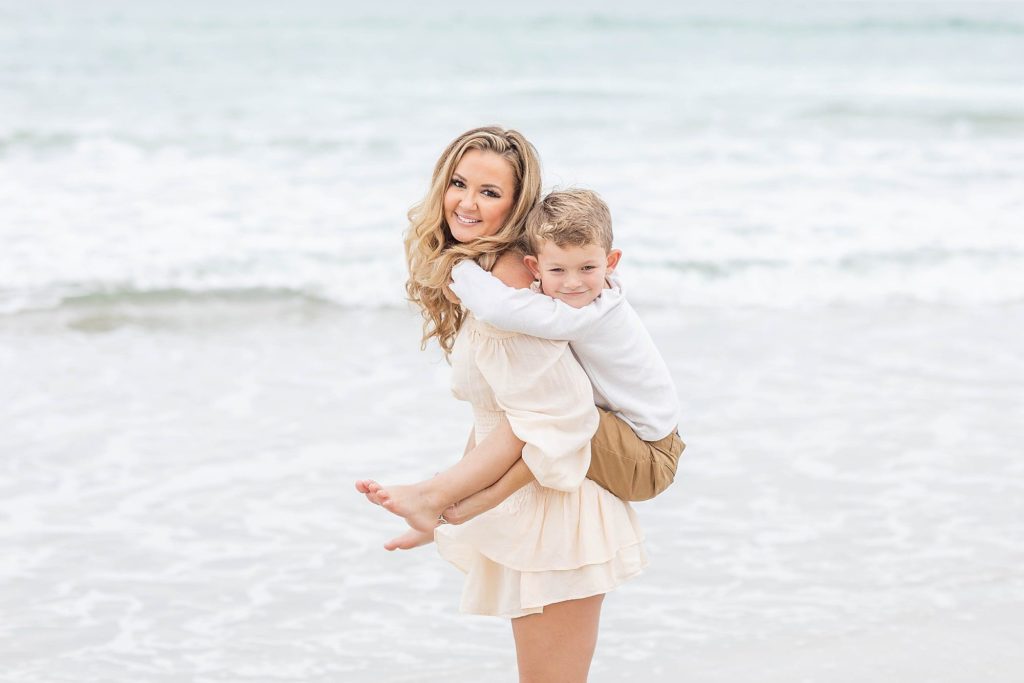 Mom giving her a little boy a piggyback ride on new Smyrna Beach
